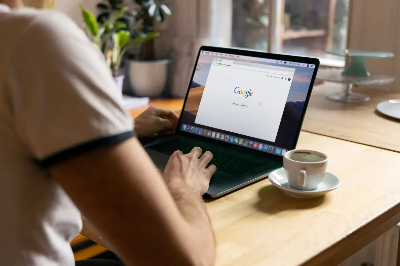Person searching online on a laptop in a cafe
