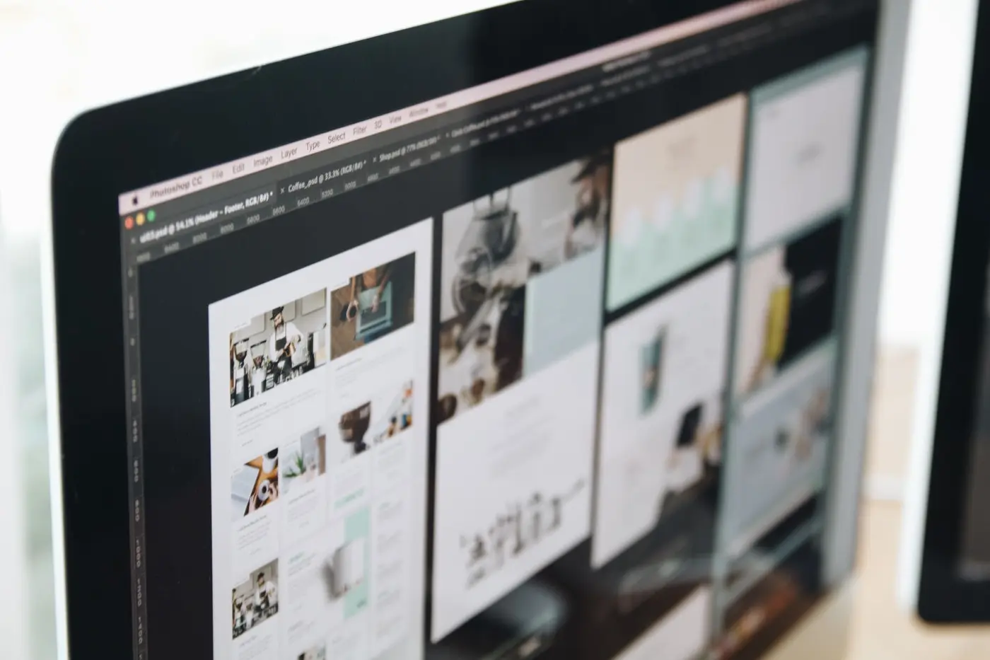 Designer reviewing website layouts on large screens